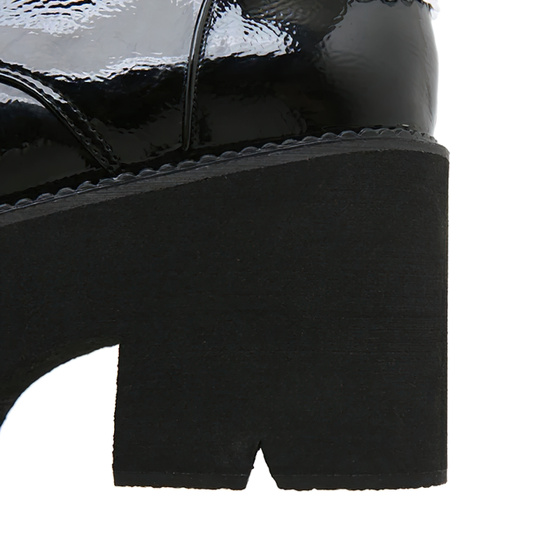 Close-up of the stylish heel of women's patent leather ankle boots with motorcycle charm.
