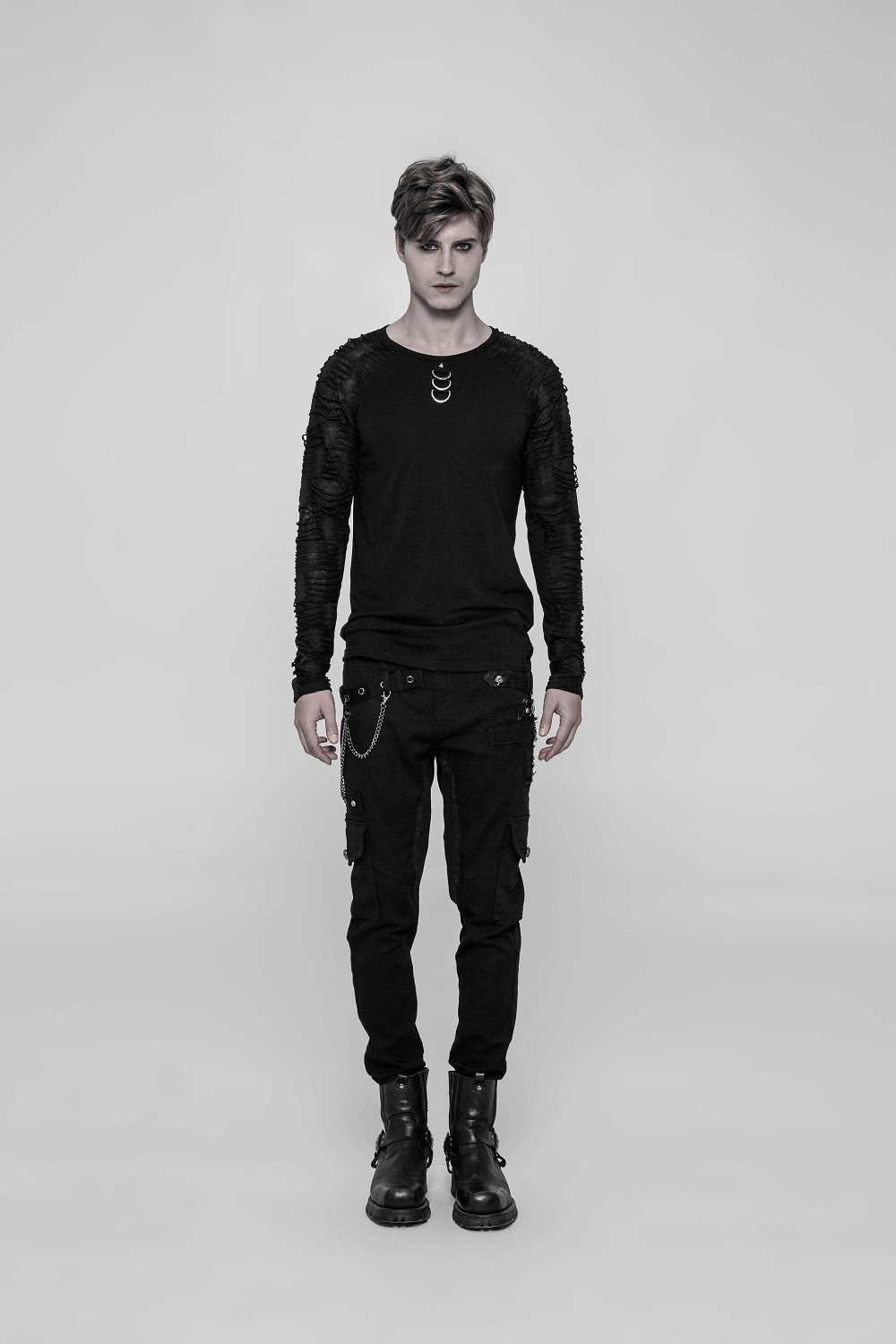 Men's black sweatshirt with ripped knit details, paired with cargo pants for a punk urban style.