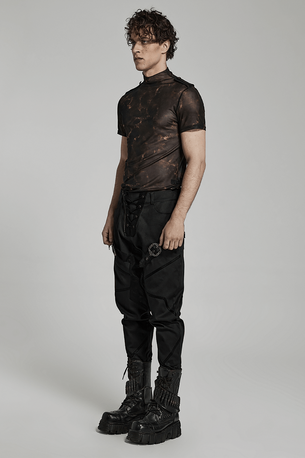 Model showcasing an abstract print stretch mesh tee with 3D lace shoulders, styled with edgy black pants and chunky boots.