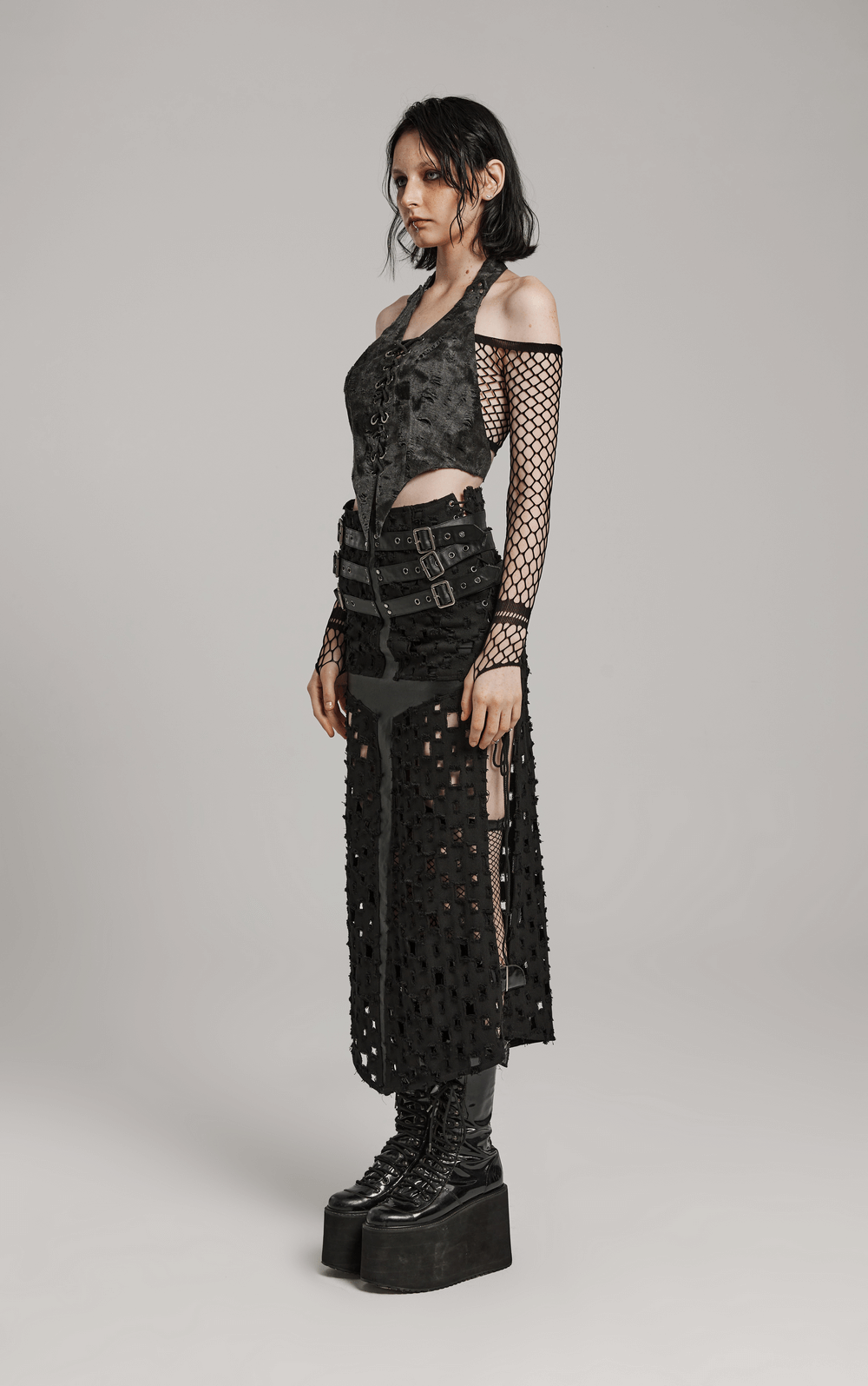 Model wearing a black punk long skirt with unique cross design and fishnet top, showcasing edgy streetwear fashion.