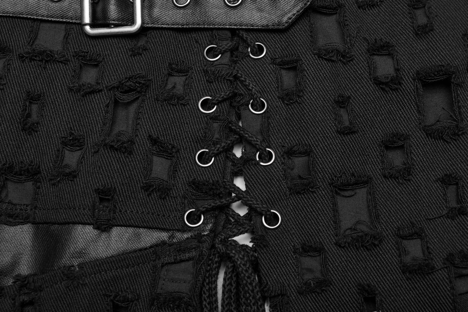 Close-up of black punk style fabric with tattered designs and lacing details, showcasing edgy fashion elements.