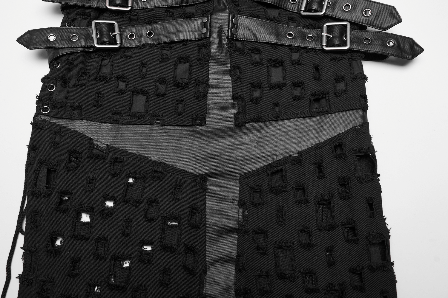 Close-up of a black punk skirt with a unique cross design and adjustable side drawstrings.