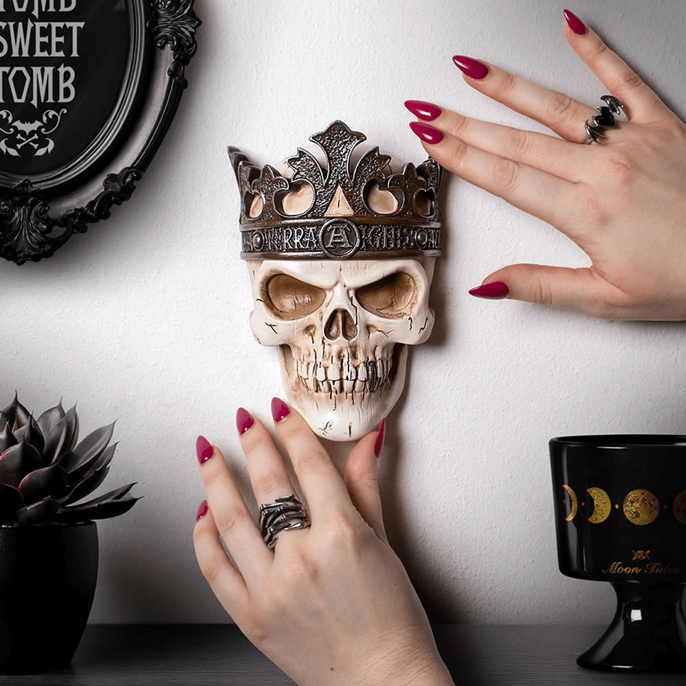 Alchemist Rex Skull Masque with metallic crown displayed against a stylish gothic wall.