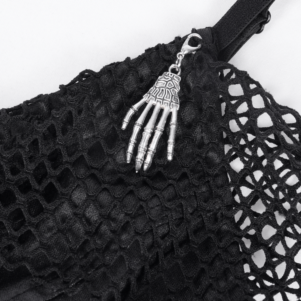 Close-up of black lace detail on gothic dress featuring silver skeleton hand charm.