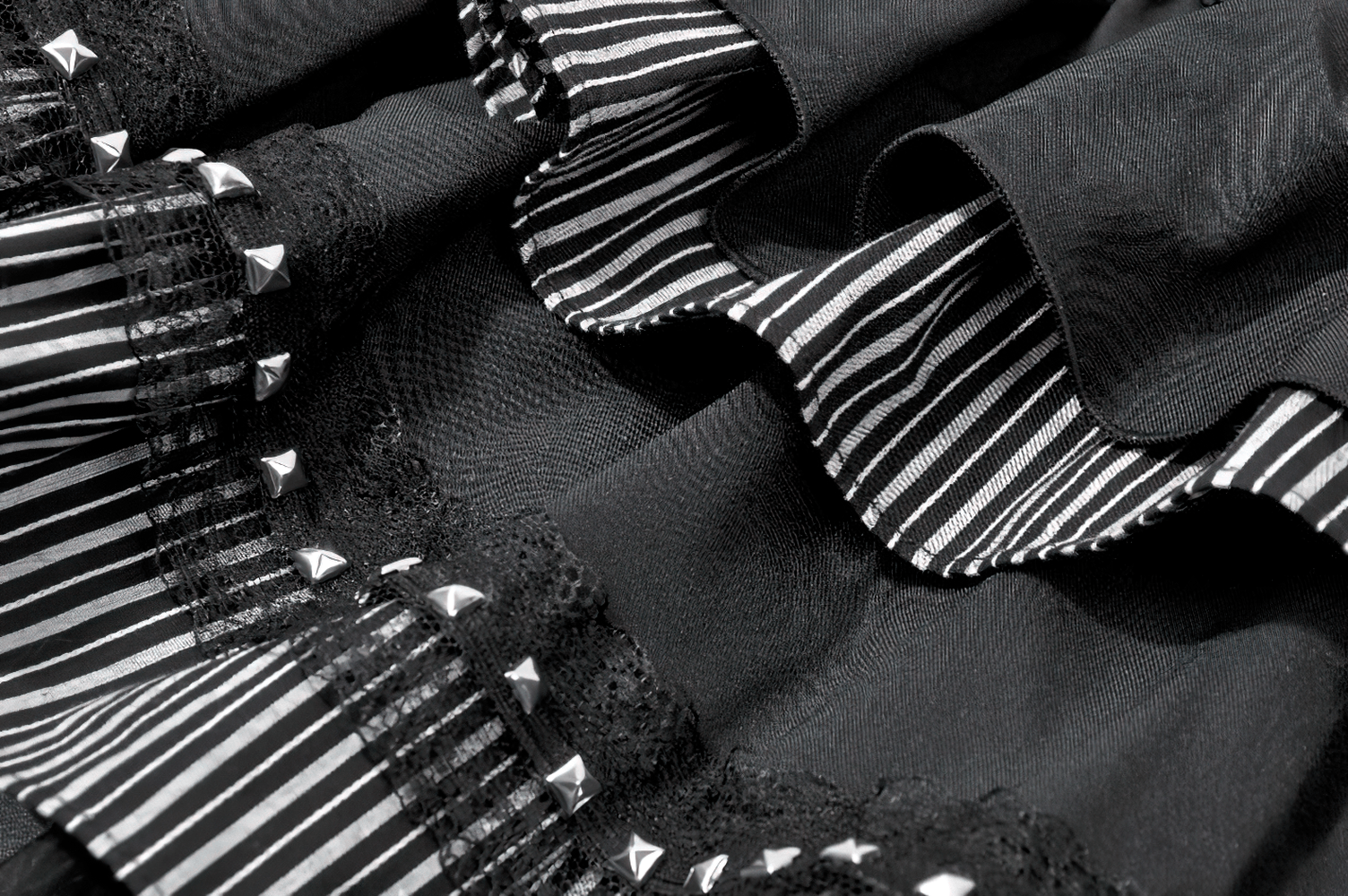 Alternative High Low Ruffle Skirt with Sheer Lace Train featuring ruffles, stripes, and studded details.