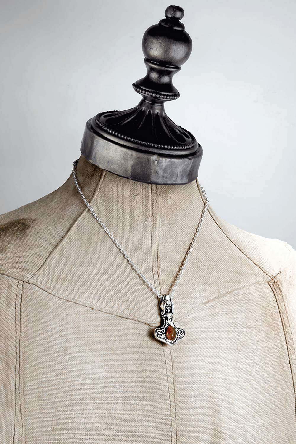 Amber Norse Thor hammer pendant with dragon design, Celtic knotwork, and genuine amber gemstone on a silver chain.