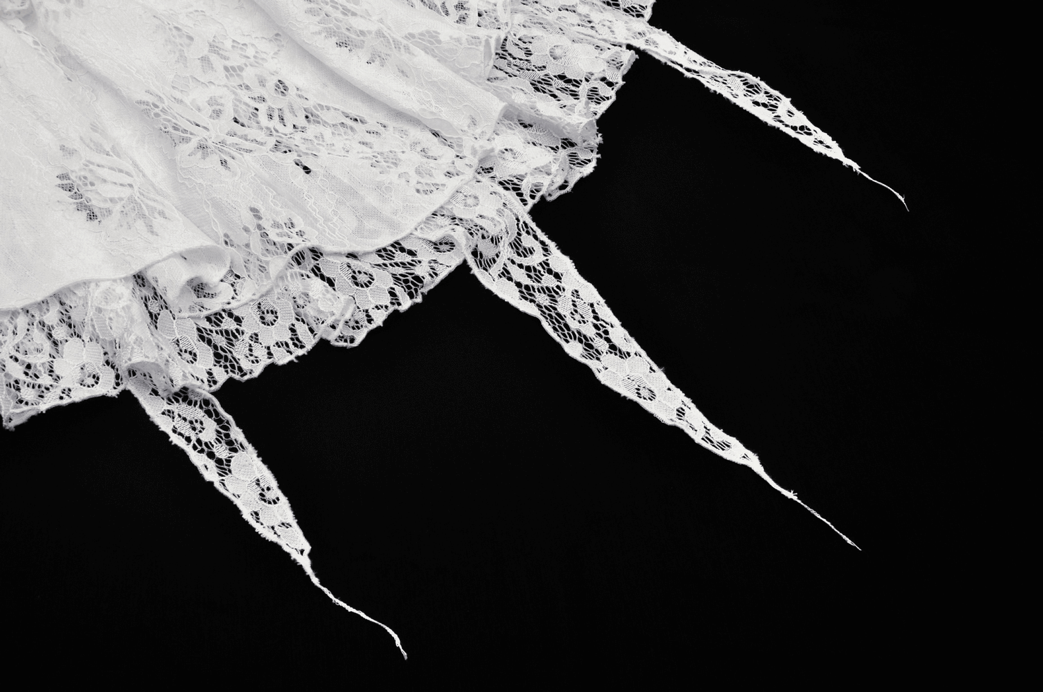 Lace detail of an ethereal white mini skirt with cascading ruffles, perfect for Gothic night adventures.