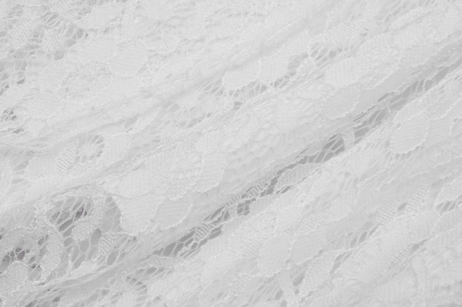 Delicate white lace fabric showcasing intricate patterns, perfect for an ethereal mini skirt or other feminine designs.