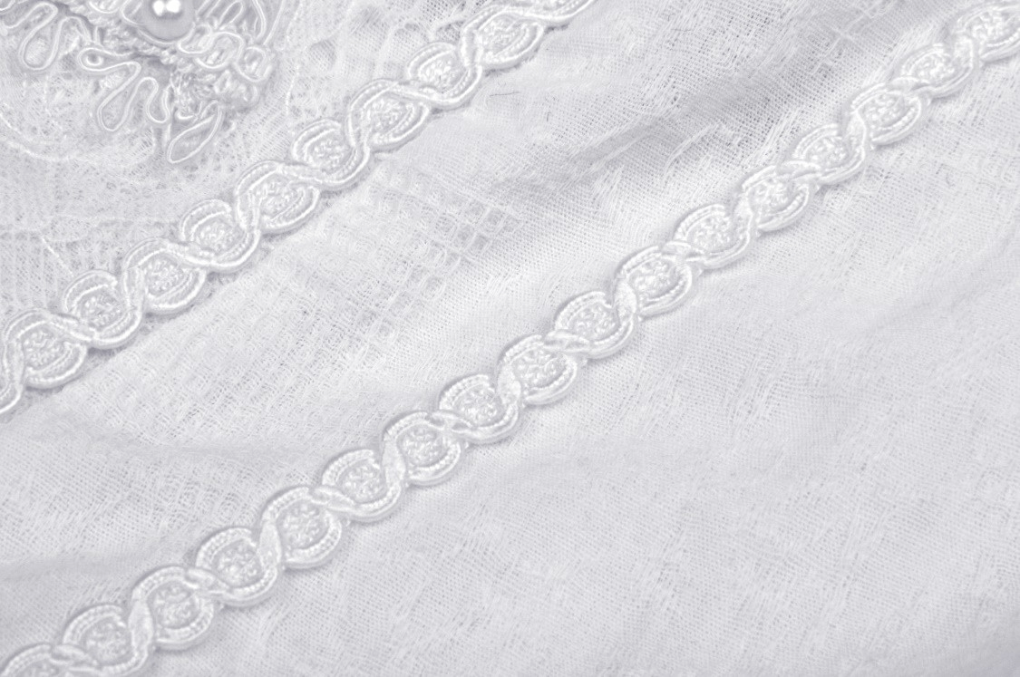 Delicate white lace trim and intricate beading detail on a gothic Lolita mini dress fabric.