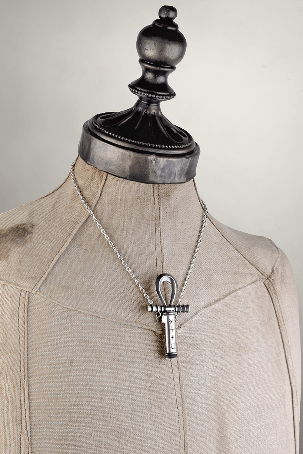 Ankh pendant with removable dagger and Egyptian symbols displayed on a vintage mannequin.