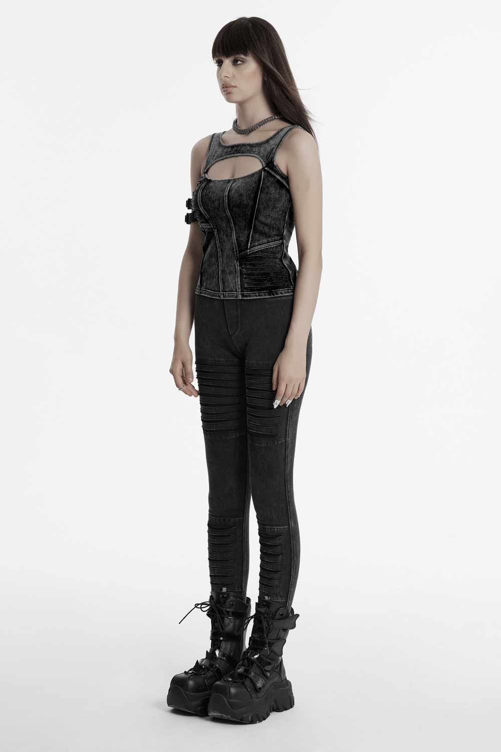 Model showcasing a distressed black knitted outfit with punk-inspired design elements and edgy ankle boots.