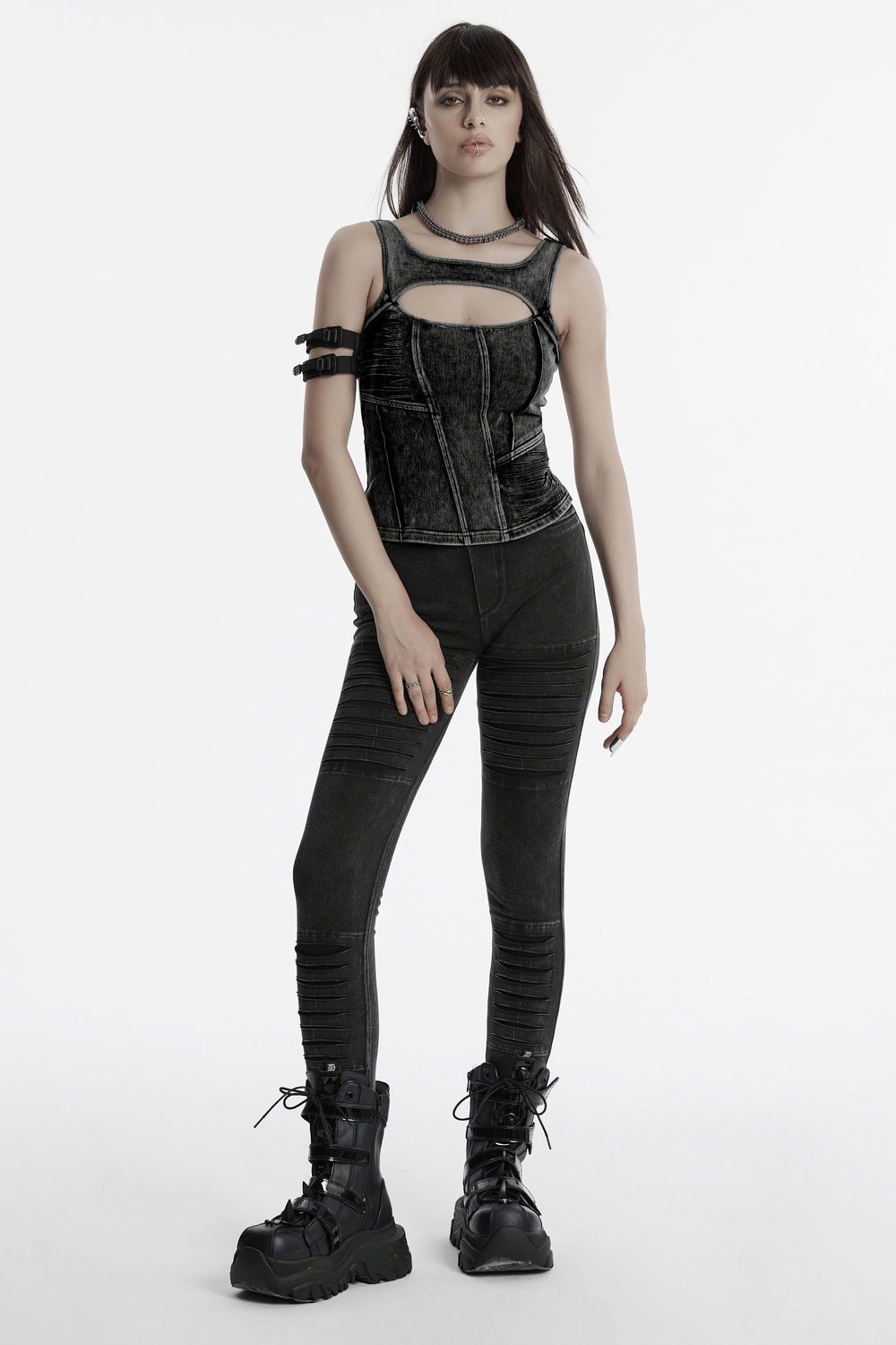 Model showcasing a black cropped top and leggings, styled with edgy boots, perfect for a punk-inspired look.
