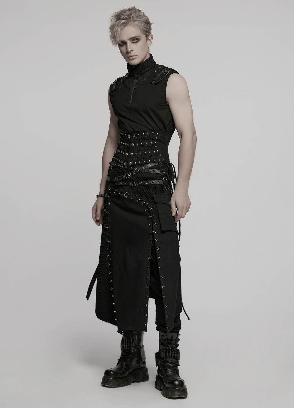 Asymmetric male gothic skirt with metal snap accents, styled with a sleeveless top and chunky boots.