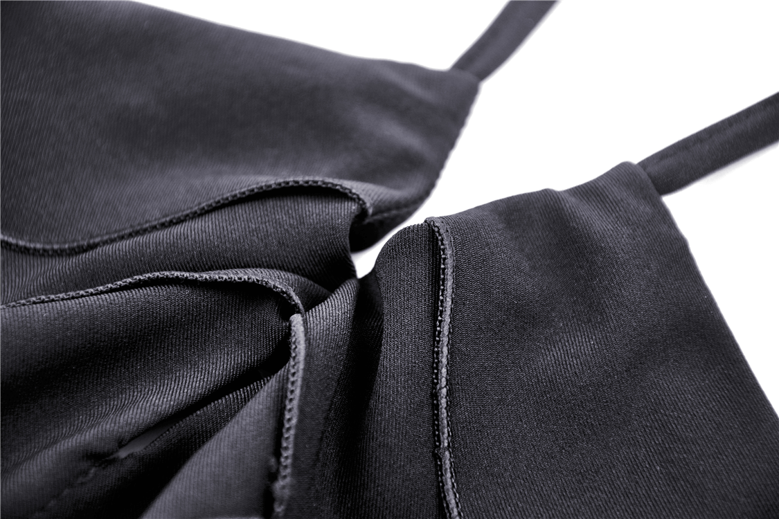 Close-up of black dress fabric showcasing butterfly straps and intricate design details.