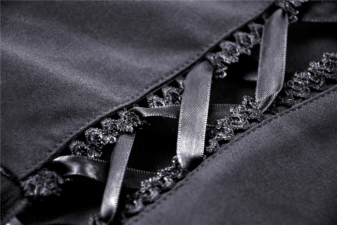 Intricate black fabric showing lace detail and satin ribbons, perfect for a Gothic dress.