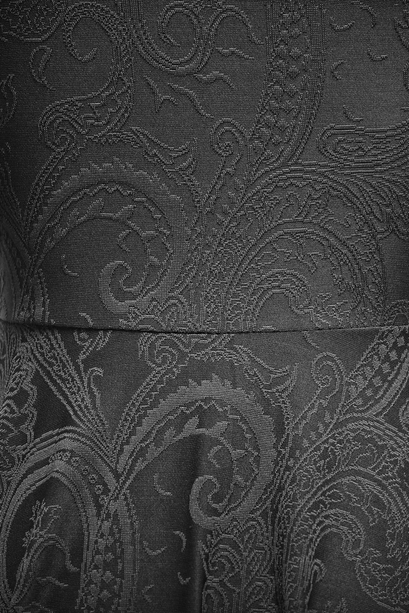 Close-up of gothic black lace dress featuring intricate paisley patterns and elegant texture.