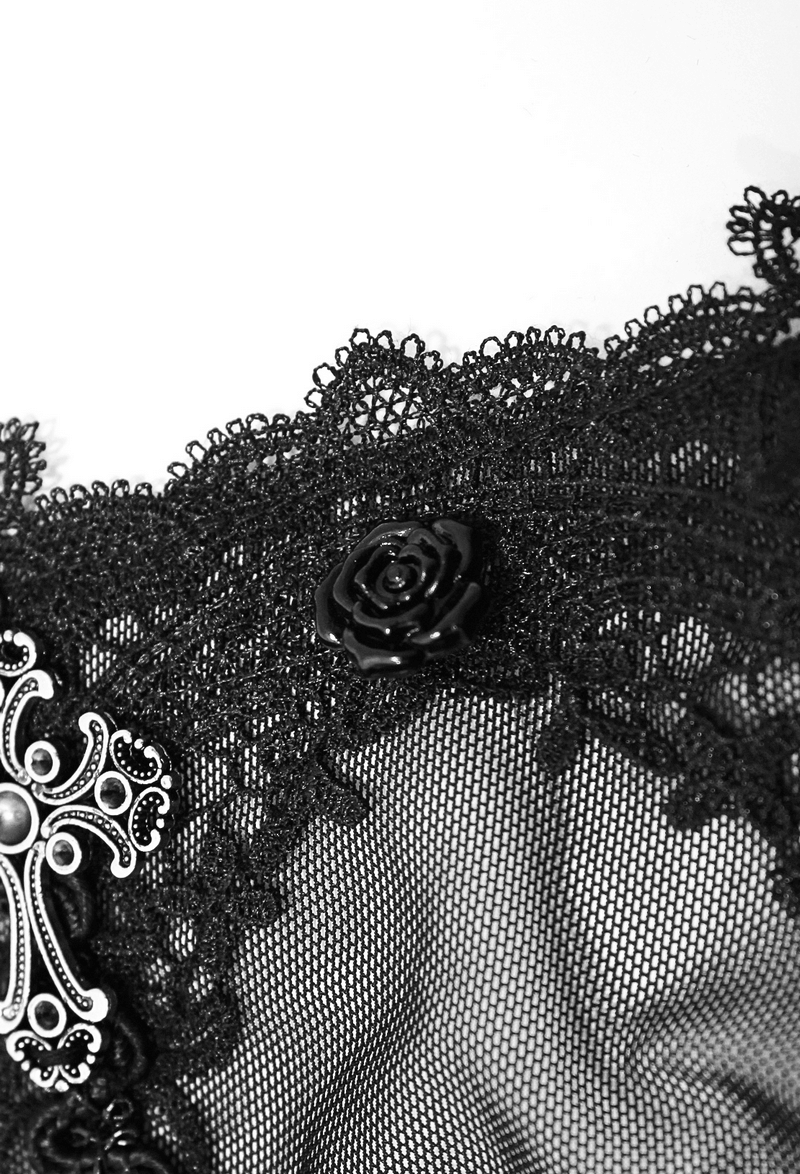 Close-up of black lace with detailed floral decoration and silver cross, showcasing gothic elegance and intricate design.