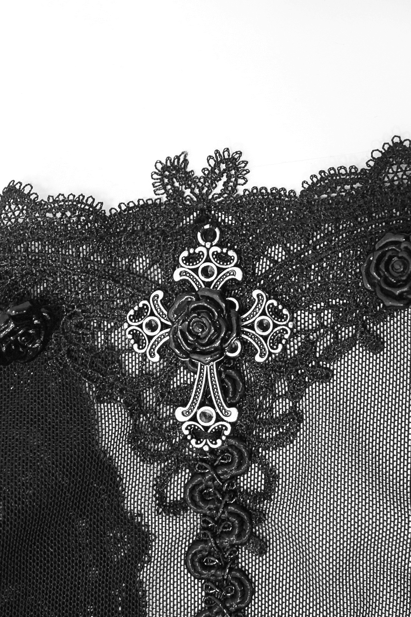 Close-up of intricate lace details with silver cross and rose embellishments on a gothic dress.