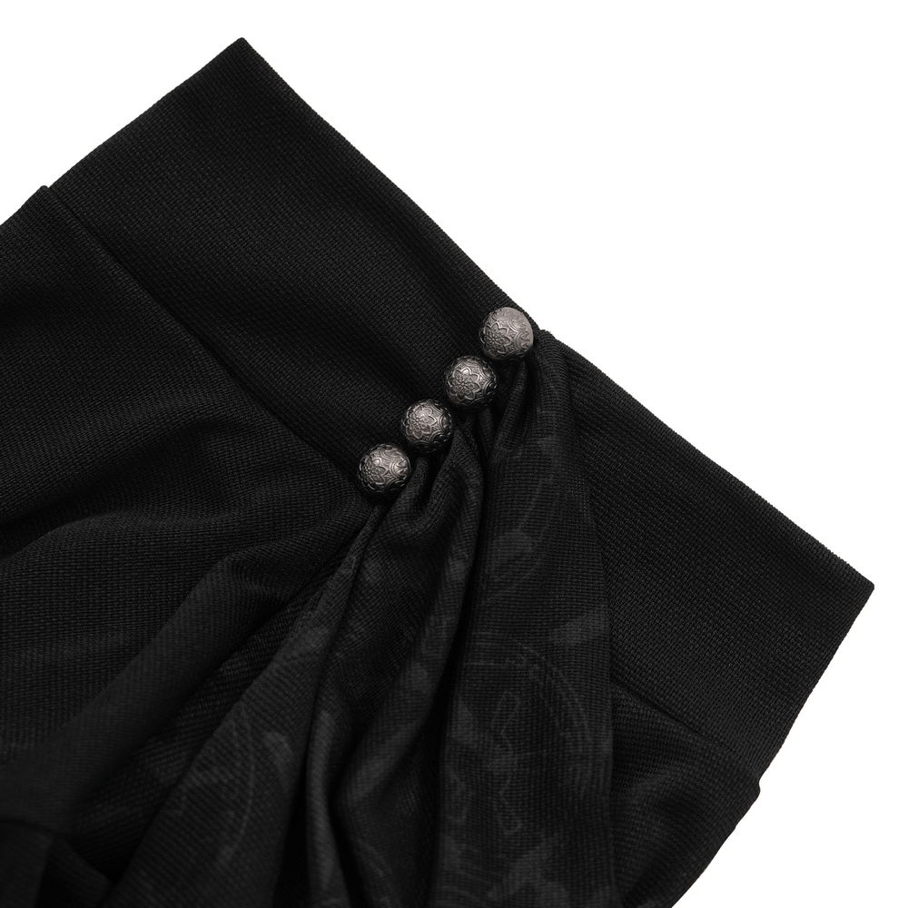 Close-up of black asymmetrical top featuring intricate fabric folds and silver button accents for a gothic look.