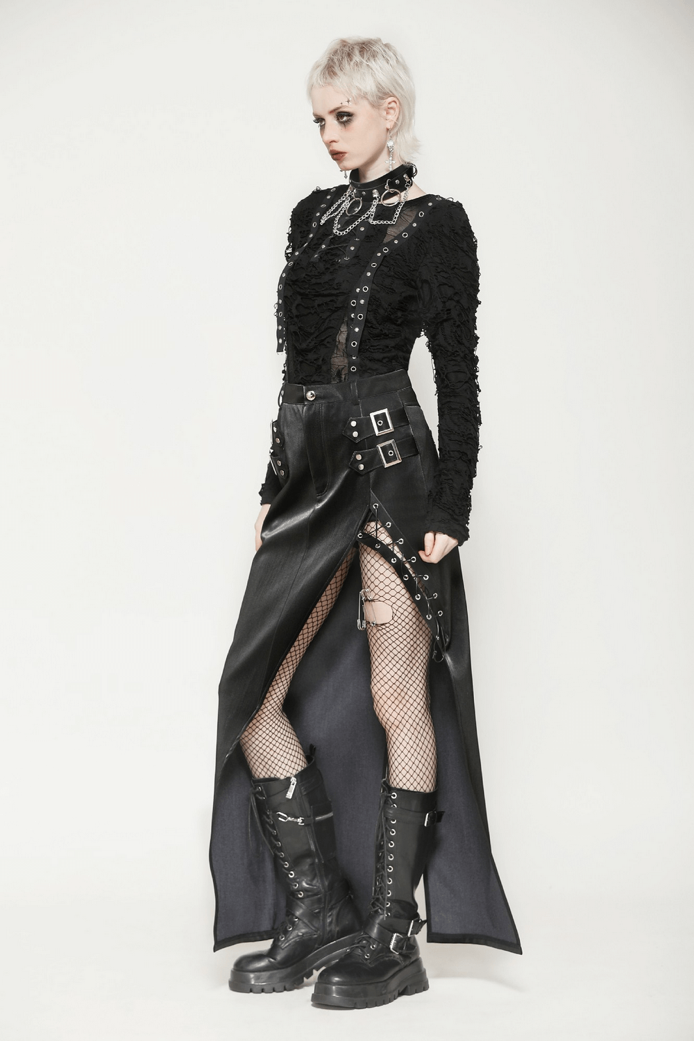 Edgy model showcasing an asymmetrical black PU leather skirt with buckles and lace-up details, paired with combat boots.