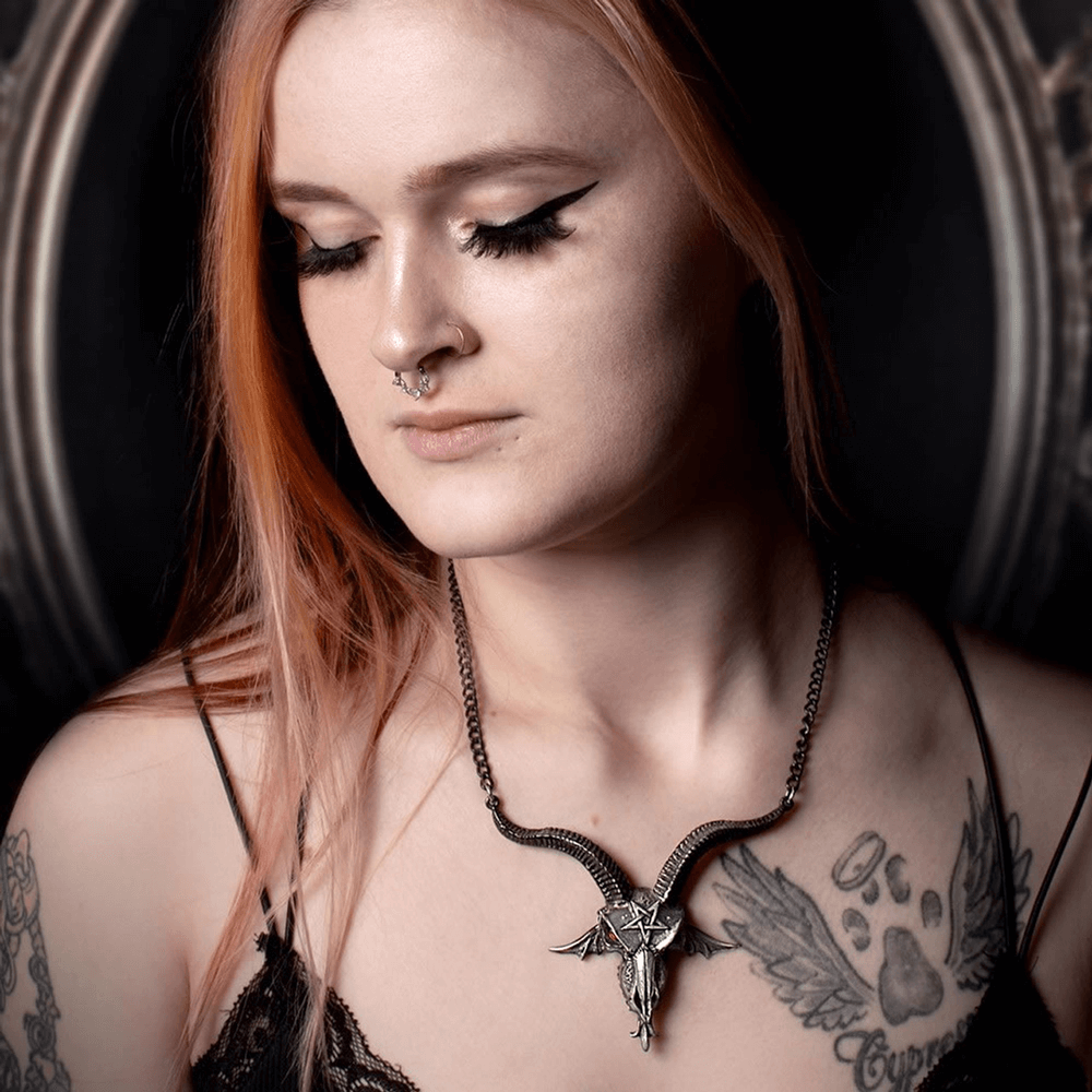 Model wearing a Baphomet Skull Necklace with red crystal eyes, showcasing gothic elegance and mystical allure.