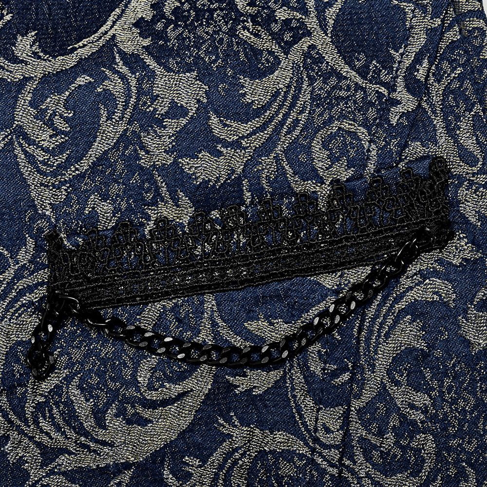 Close-up of navy jacquard fabric with intricate baroque patterns and a lace-trimmed pocket on a tailored vest.