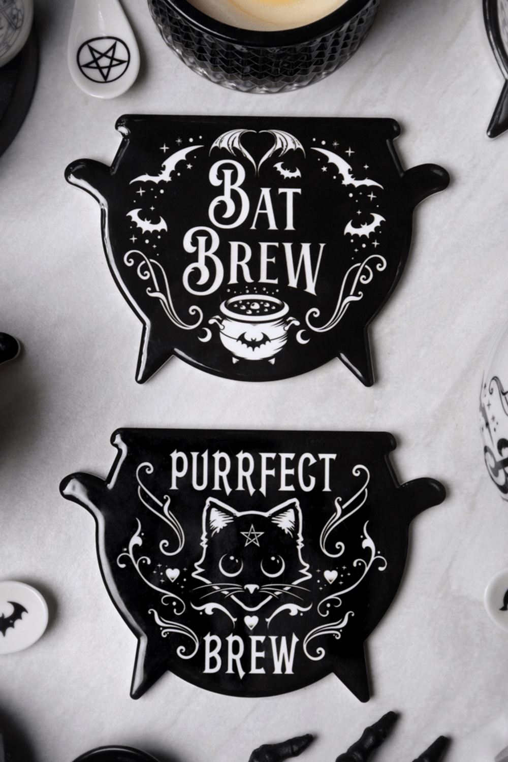Ceramic Bat Brew and Purrfect Brew coasters for gothic home decor, featuring spooky designs and cauldron shapes.