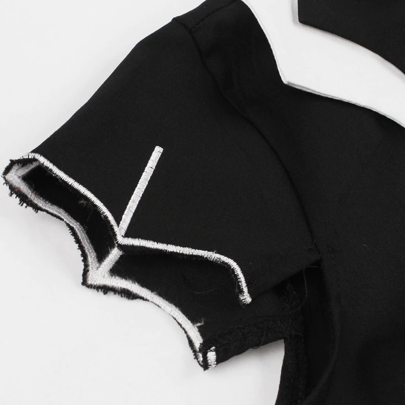 Close-up of the embroidered sleeve of a black gothic dress featuring unique white detailing.