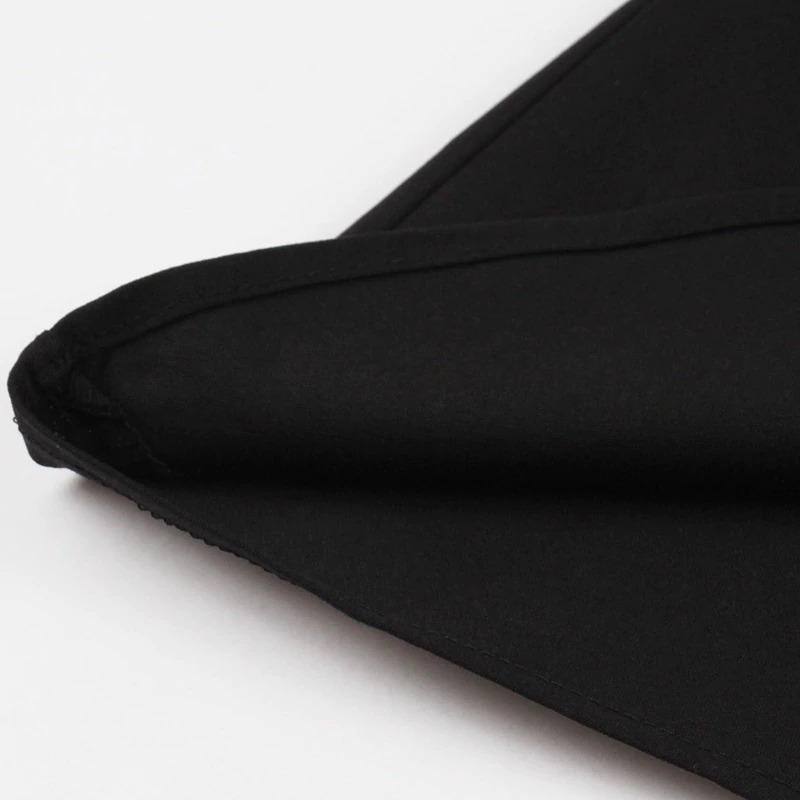 Close-up of the hem of a black gothic dress, showcasing the fabric and stitching details for Halloween fashion.