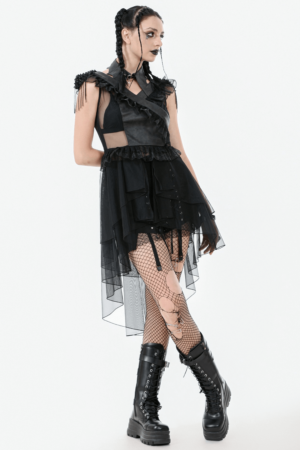 Gothic model in a layered black dress, fishnet tights, and combat boots, showcasing an edgy alternative fashion style.
