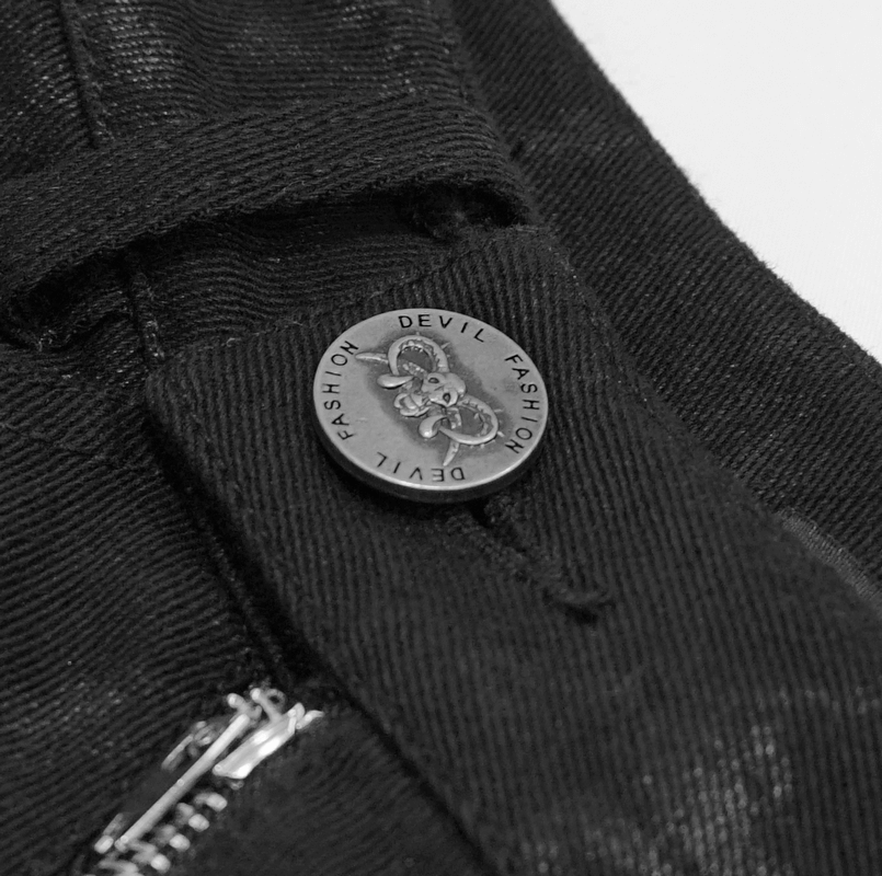 Close-up of black skinny jeans featuring a unique devil fashion button and stylish zipper detail.