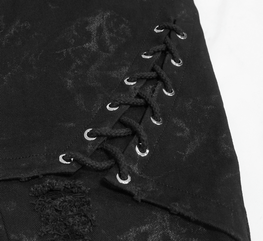 Close-up of black punk skinny jeans with stylish lace-up detail and silver eyelets.