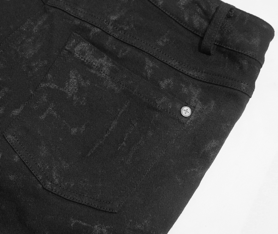 Close-up of women's black skinny jeans featuring a distressed texture and stylish back pocket detail.