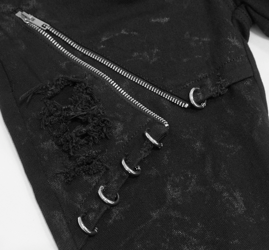 Close-up of black punk skinny jeans featuring distressed fabric, silver zippers, and lace-up details.