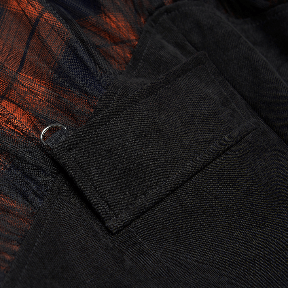 Close-up of black and orange plaid skirt showing pocket and D-ring buckle detail for punk rave style.