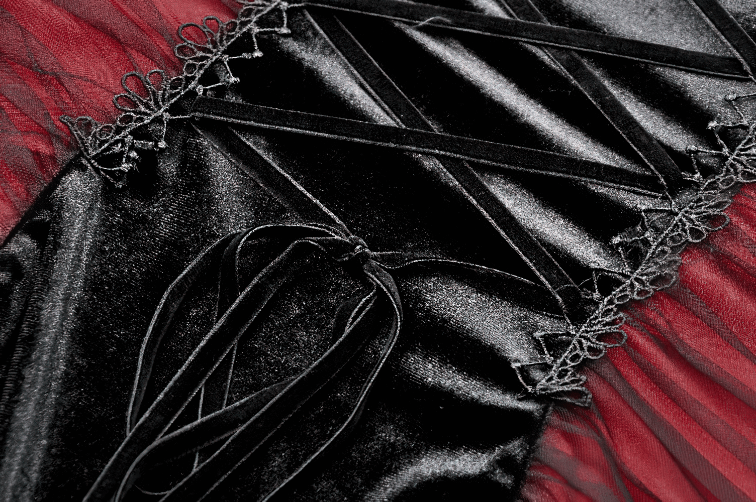 Close-up of black and red gothic lace-up dress with intricate detailing and sheer panels.