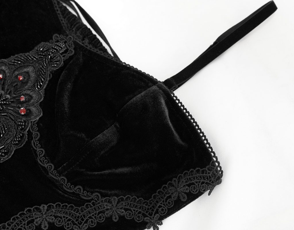 Close-up of black velvet dress with lace detailing and red accents, highlighting gothic elegance.