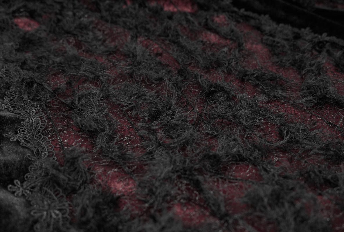 Close-up of black and red velvet fabric with lace details, showcasing gothic elegance and intricate texture.