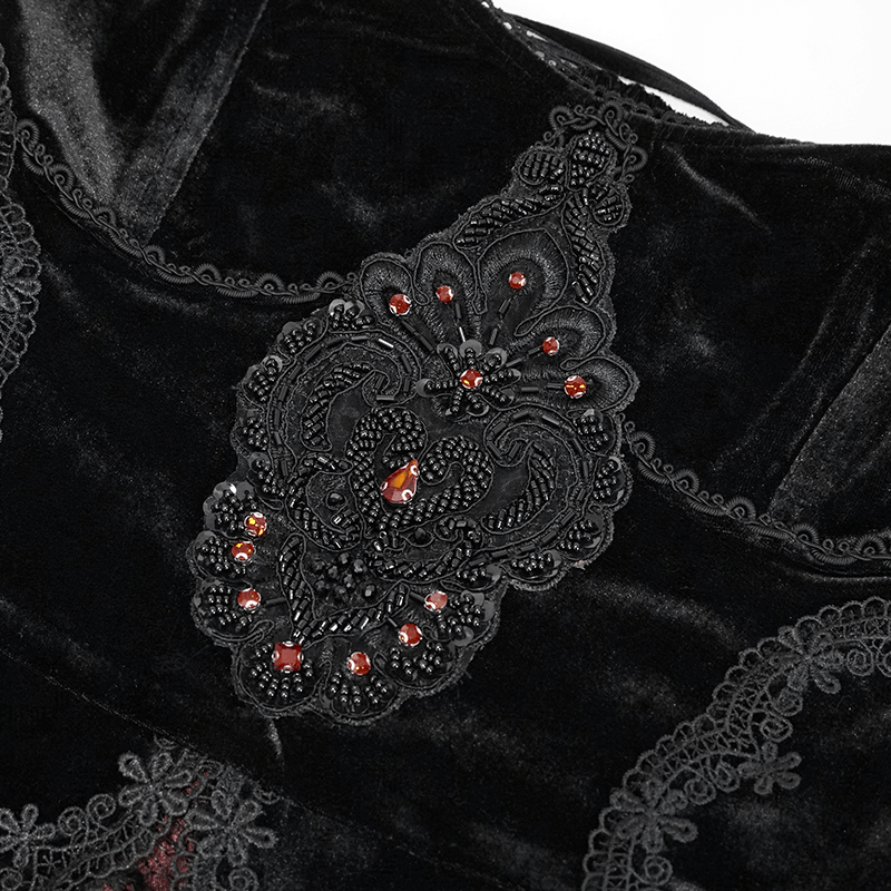 Close-up of exquisite lace and jewel embellishment on black gothic velvet dress, showcasing elegant design details.