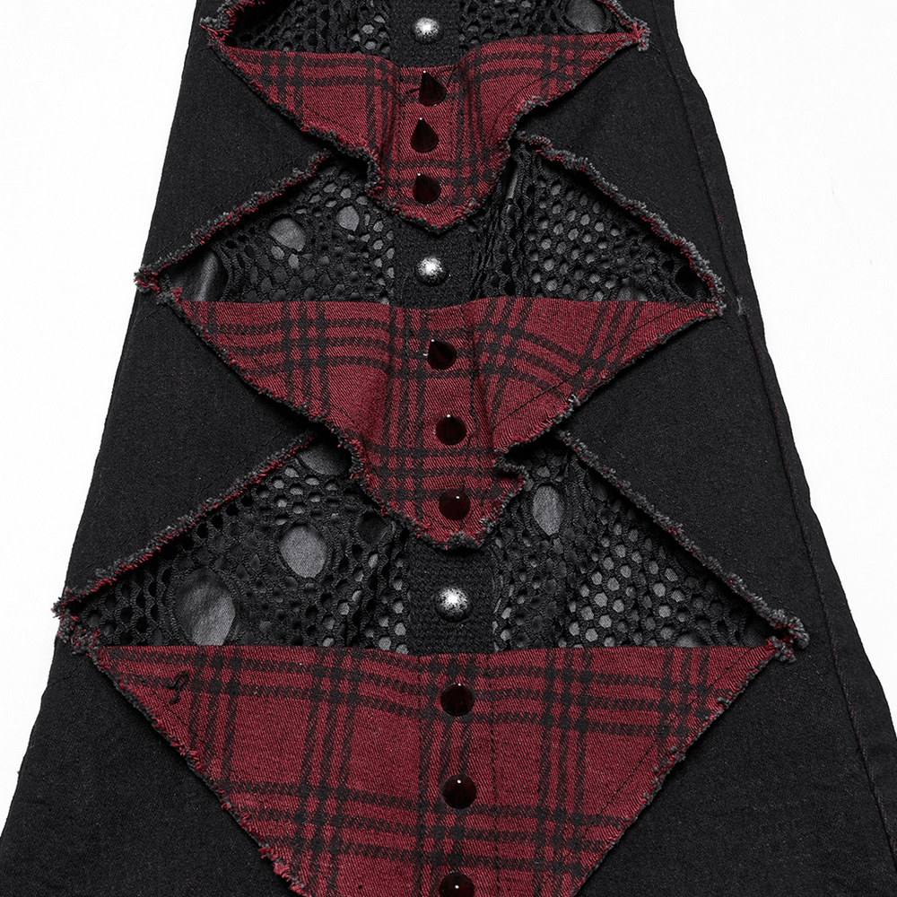 Close-up of black and red plaid gothic flared pants with mesh panels and metallic studs, showcasing unique layered design.