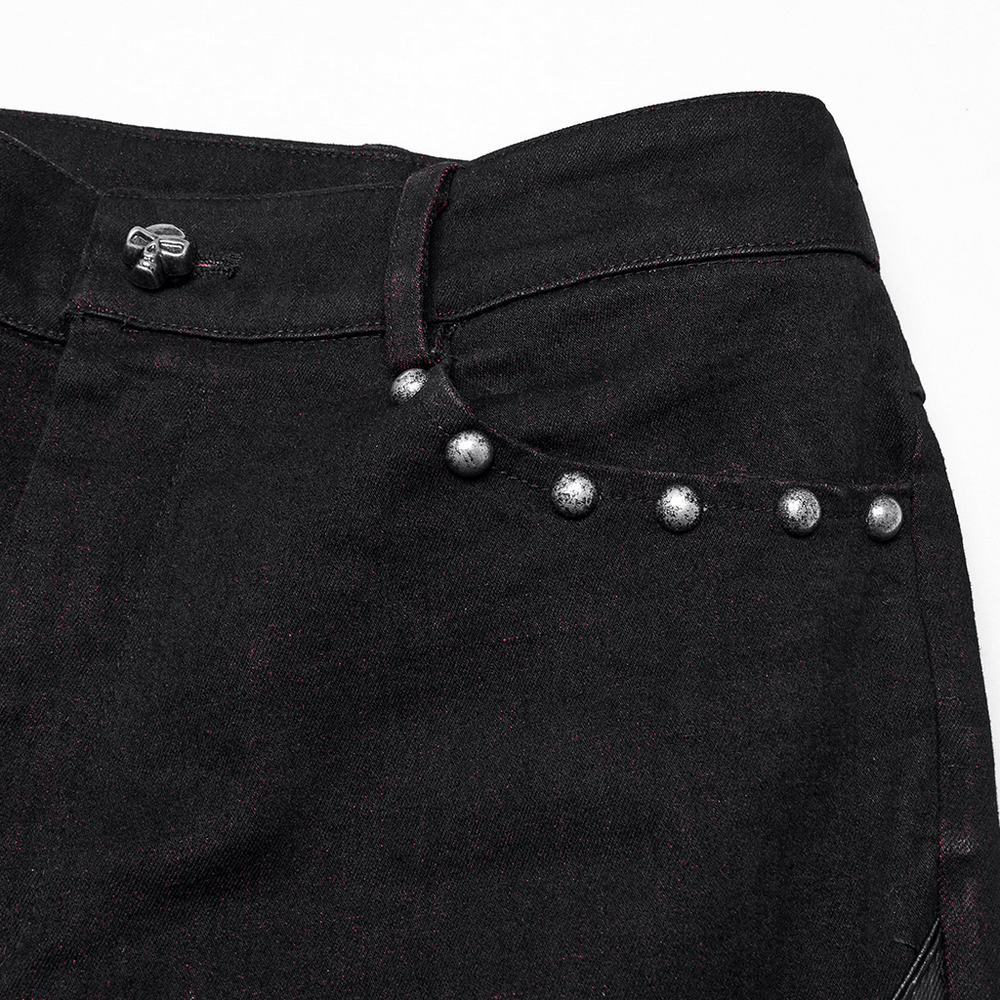 Close-up of black denim pants featuring metallic studs and intricate detailing for a punk gothic style.