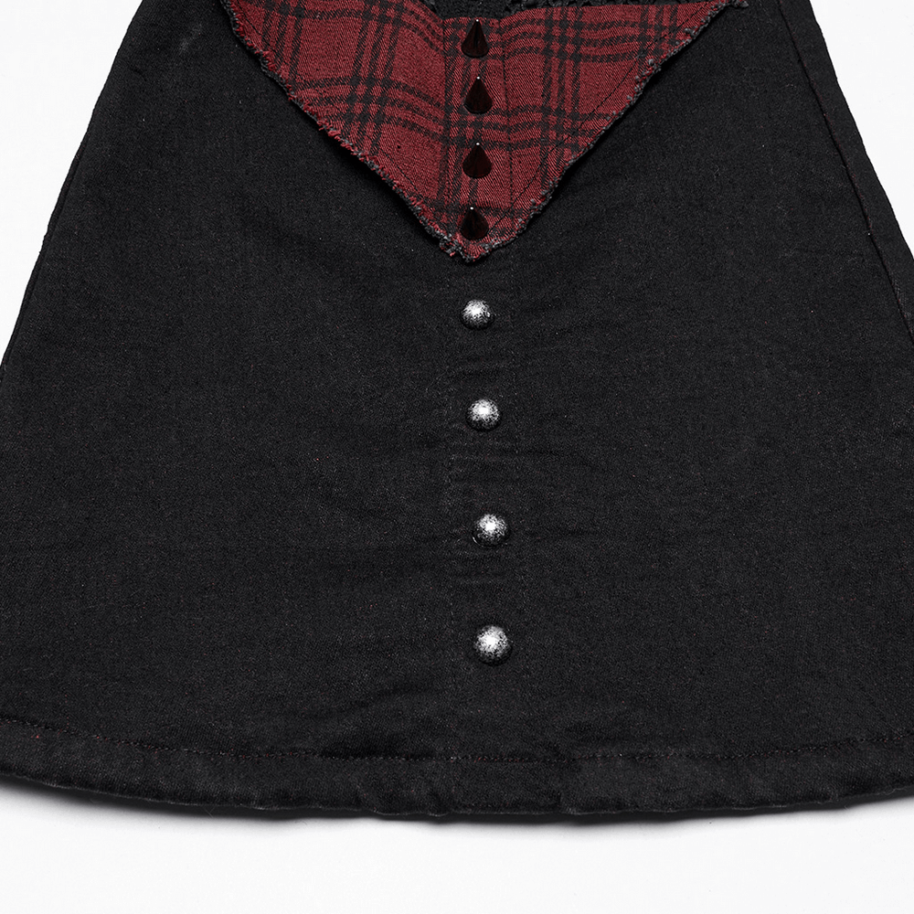 Close-up of black and red plaid gothic flared pants with metallic studs and mesh detailing.