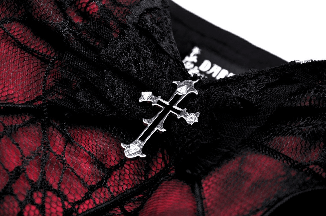 Close-up of a gothic dress featuring a red spiderweb print and a silver cross detail on a black bow.