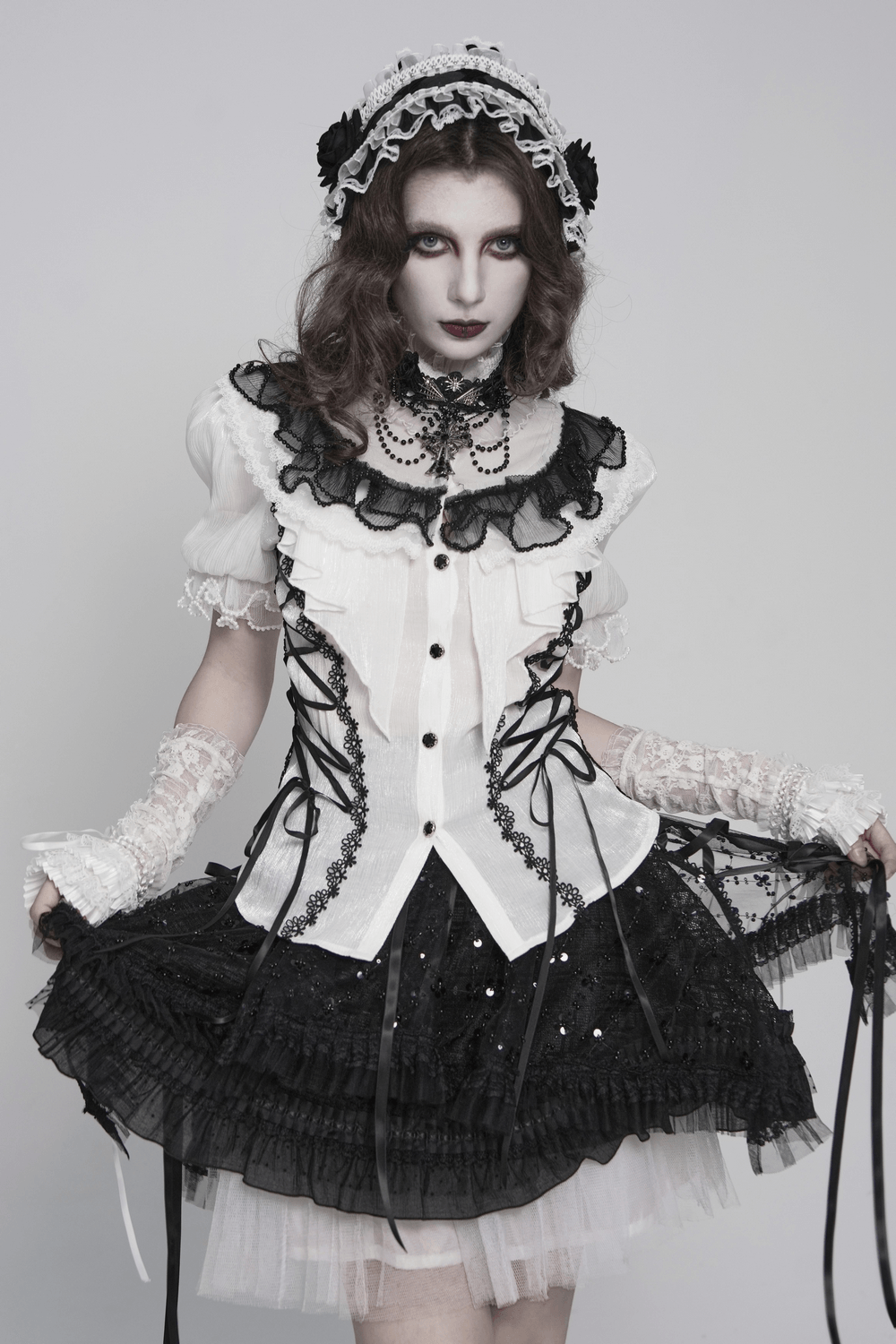 Black and White Gothic Lolita Lace Bonnet with Roses worn with a black and white ruffled outfit and dramatic makeup.