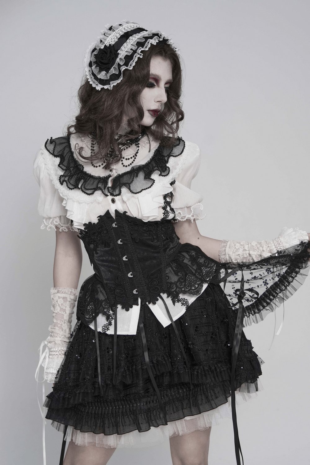 Model showcasing a Black and White Gothic Lolita Lace Bonnet with Roses, styled in a dramatic dark romantic outfit.
