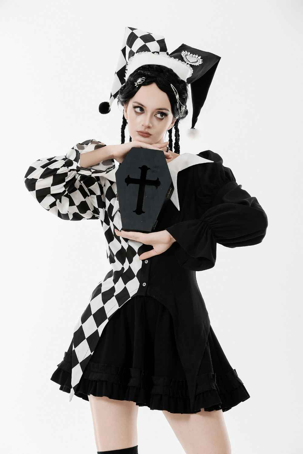 Black and White Harlequin Jester Hat with Lace Trim worn by model holding a black coffin prop.