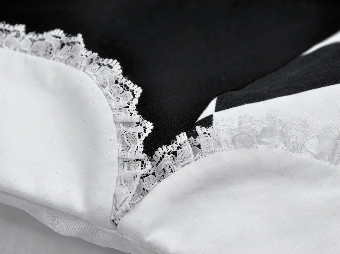 Close-up of lace trim on a Black and White Harlequin Jester Hat with Lace Trim, highlighting its detailed design.