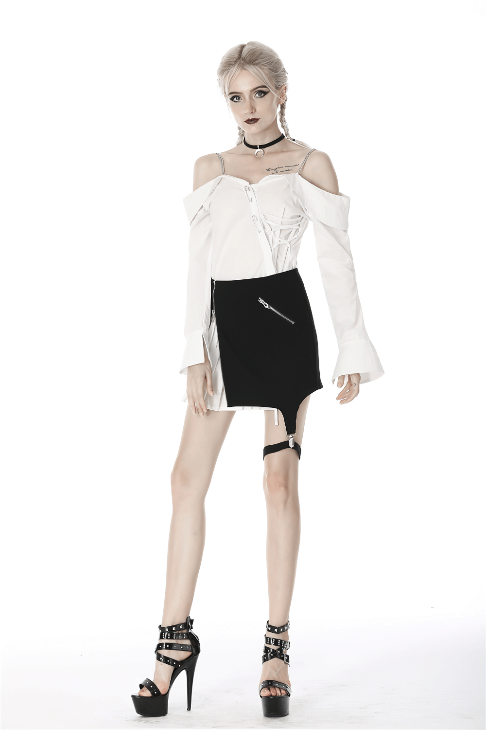Model wearing a black and white punk mini skirt with leg loop zipper and off-shoulder top, showcasing edgy fashion.