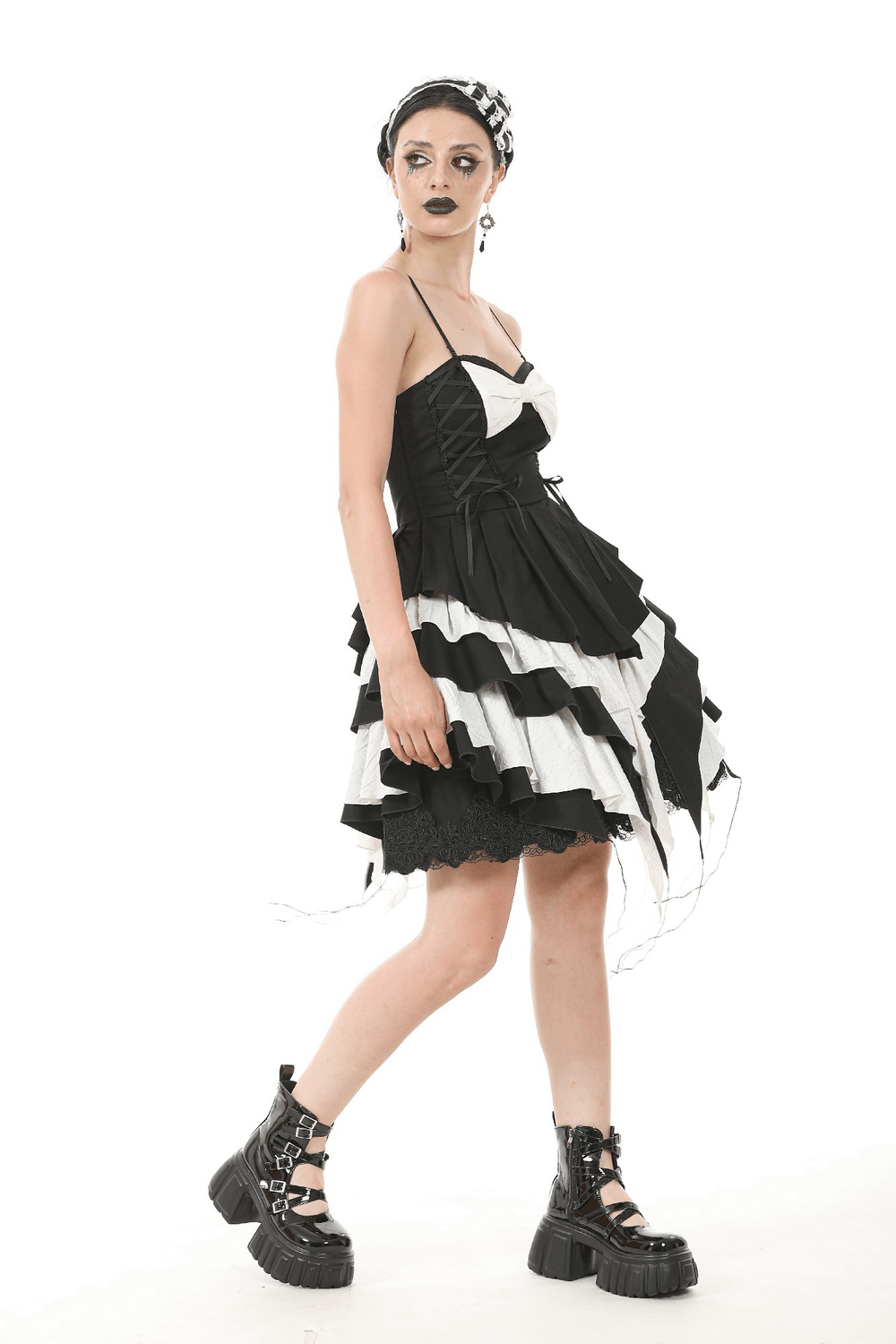 Black and white Gothic dress with ruffles, lace, and a bow, paired with chunky platform boots.