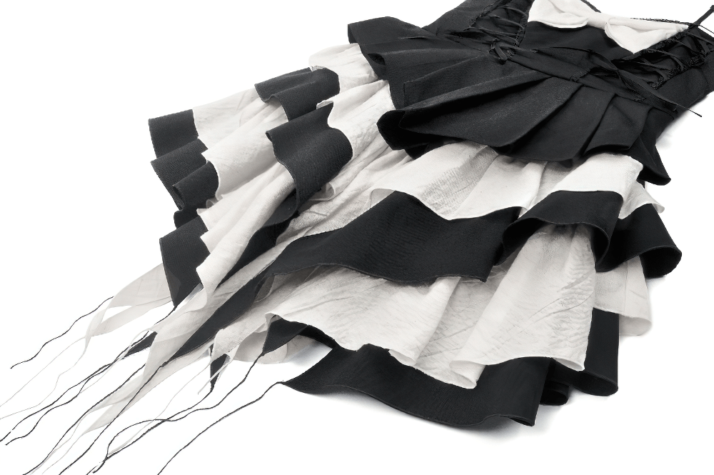Black and white ruffled gothic dress with lace, bow, and adjustable straps, perfect for alternative fashion lovers.